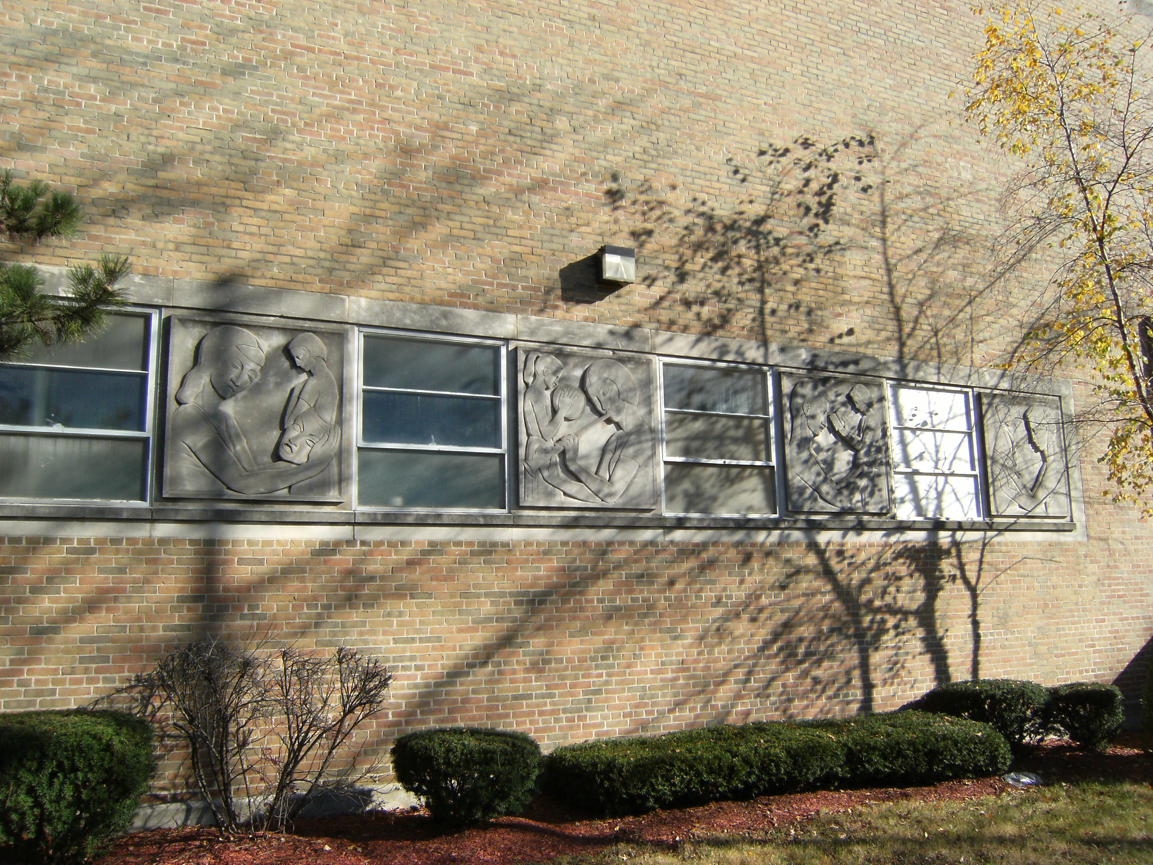 Robert Koepnick stone reliefs on exterior of auditorium. Photo shows only four of the six reliefs. Several rellefs were damaged during demolition and all are stored at a DPS storage facility.